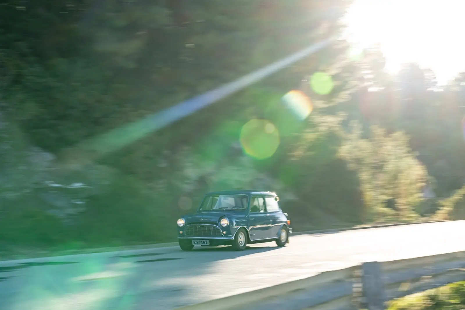 木漏れ日の道を走る1959年のクラシックMini